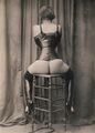 Tightlaced woman with overknee boots sitting on a barstool.jpg